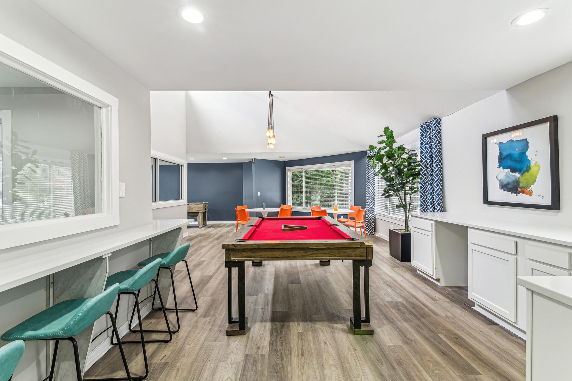 Clubroom with pool table, bar seating and table and chairs.